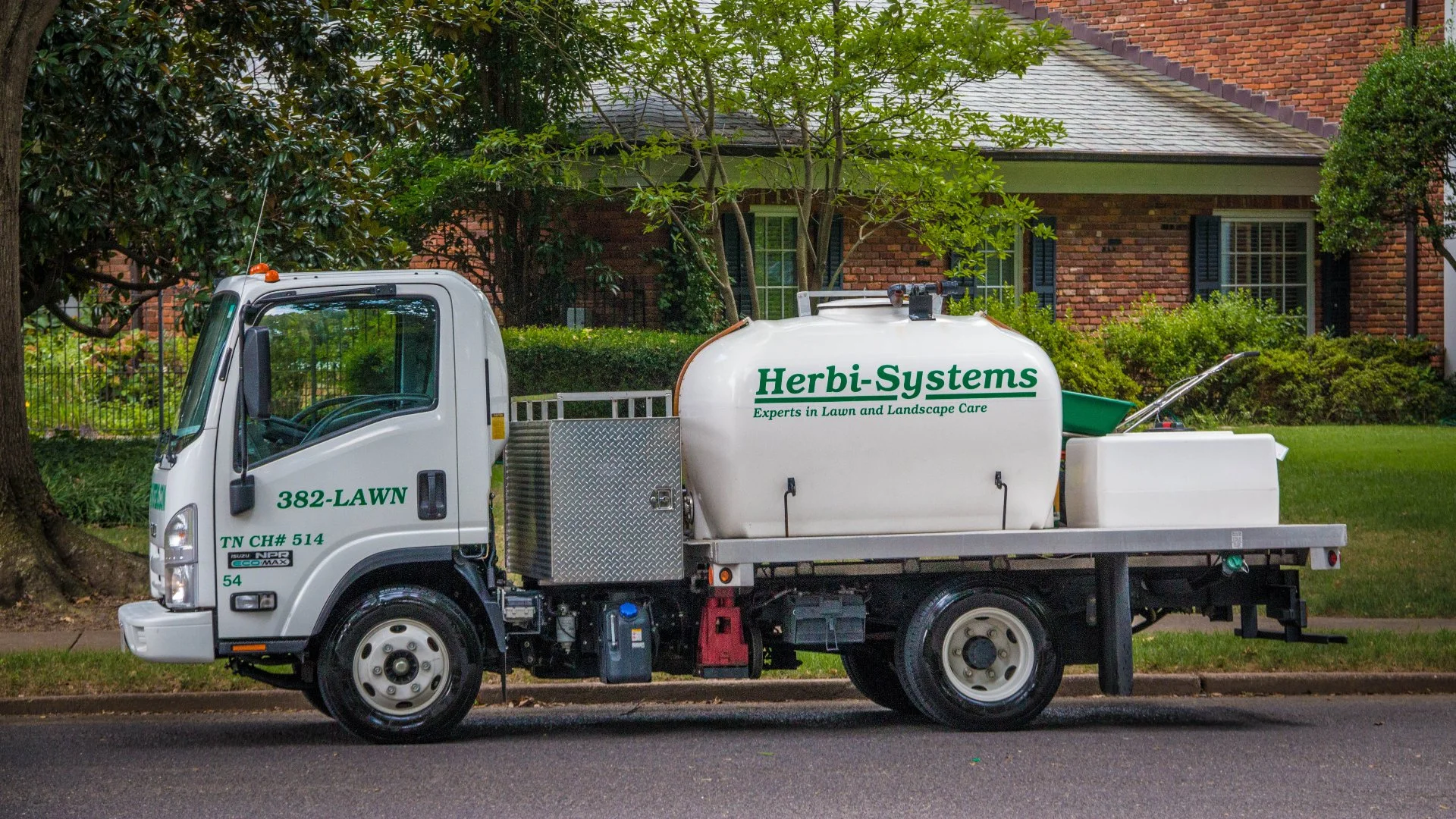 Herbi-Systems truck in front of a property.