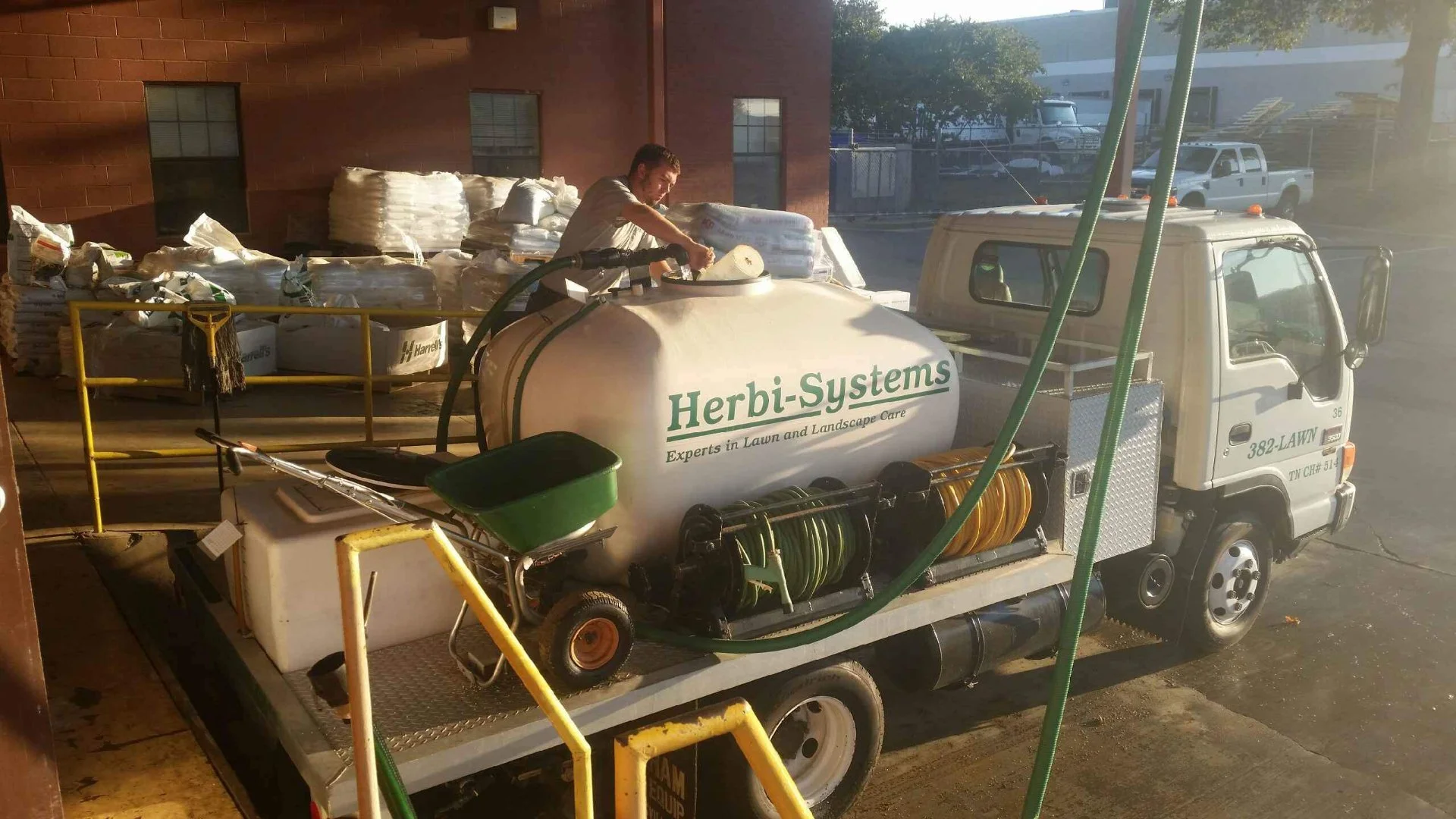 Herbi-Systems technician filling the lawn care truck with fertilizer.