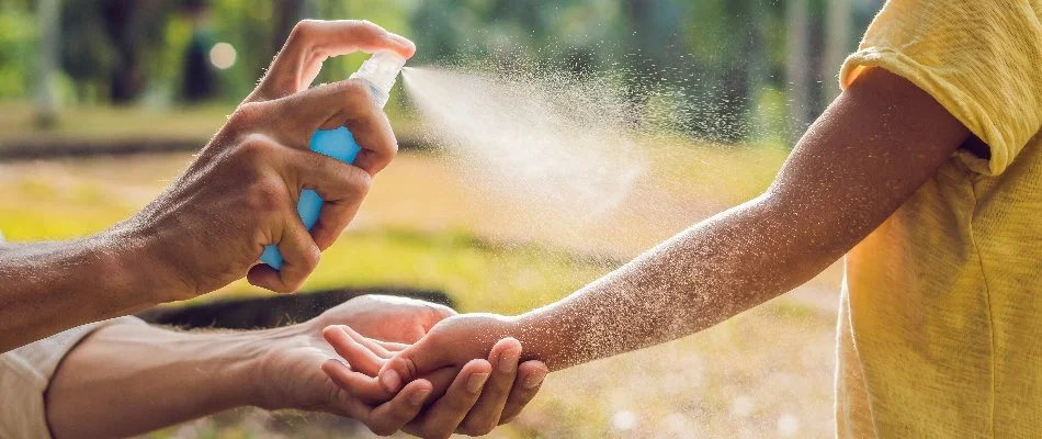 Person applying mosquito repellent on a kid in Memphis, TN.