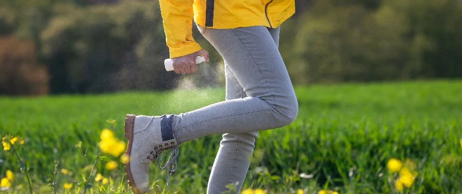 Person wearing jeans and spraying a mosquito repellent in Memphis, TN.