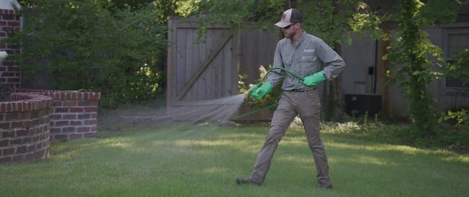 Tech applying a lawn fertilizer treatment on a property in Memphis, TN.
