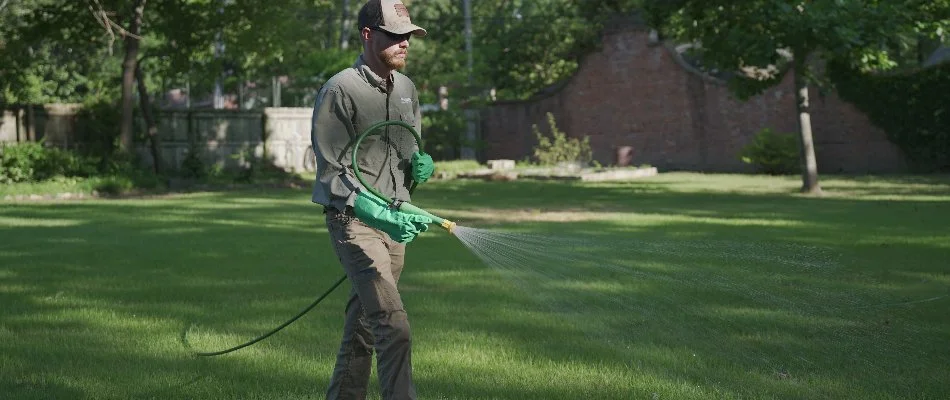 Worker spraying fertilizer treatment on a lawn in Memphis, TN.