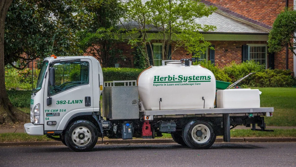 Herbi-Systems fertilization and weed control truck servicing lawns.